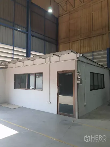 工厂 出租在Phra Pradaeng, Samut Prakan - 厂房内办公室近景，带玻璃门和窗户。