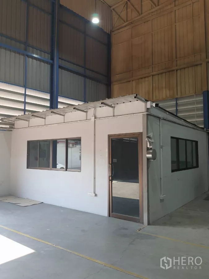 工厂 出租在Phra Pradaeng, Samut Prakan - 厂房内办公室近景，带玻璃门和窗户。