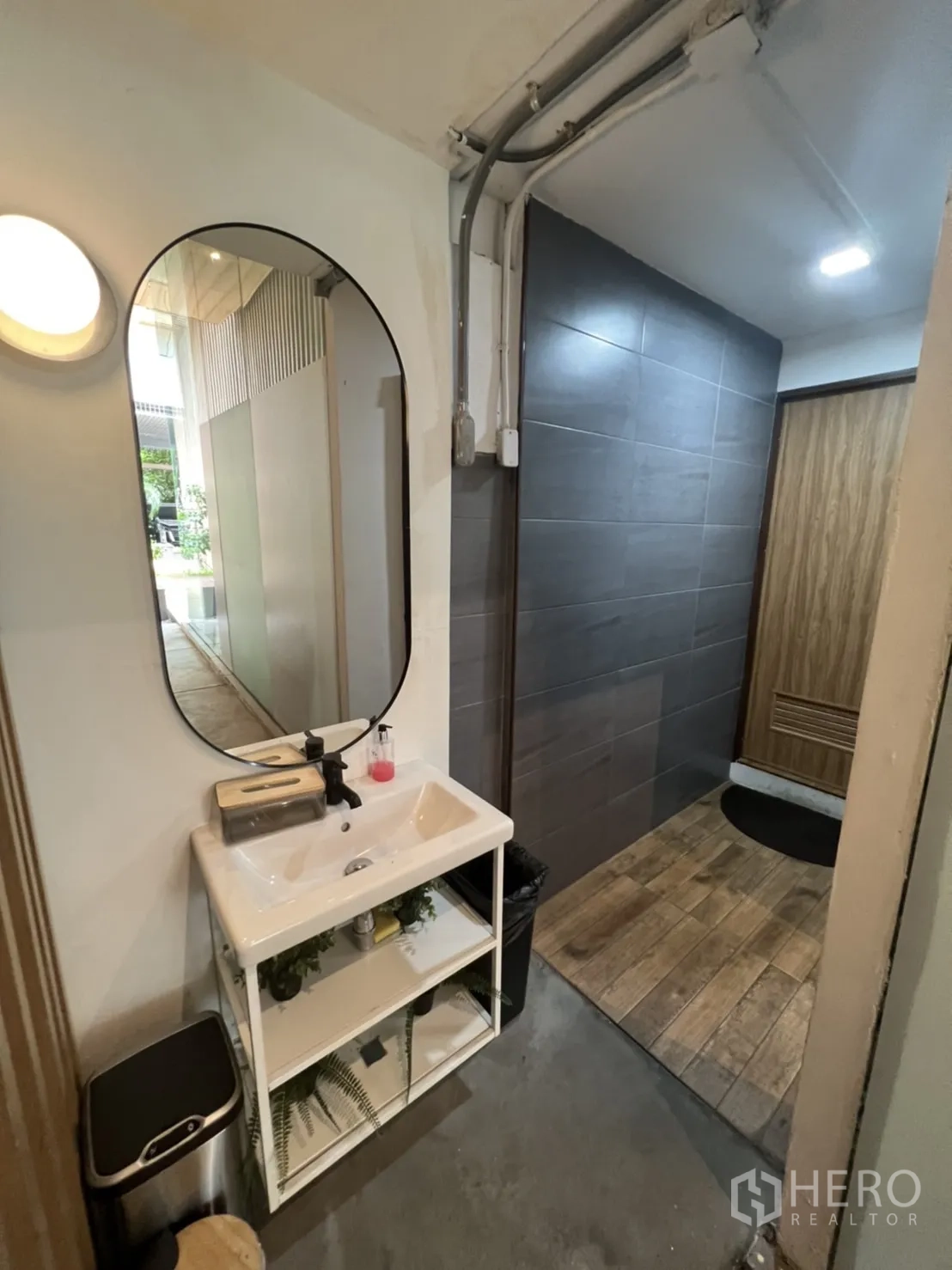 พื้นที่ขายปลีก ให้เช่าในWatthana, Bangkok - ห้องน้ำพร้อมกระจกวงรี อ่างล้างหน้า และห้องสุขาแต่งกระเบื้องสีเทา