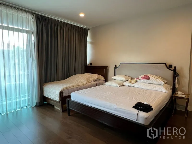 Detached House for sale in Bang Kapi, Bangkok - Master bedroom with king-size bed, daybed and full-height drapes by the balcony door.