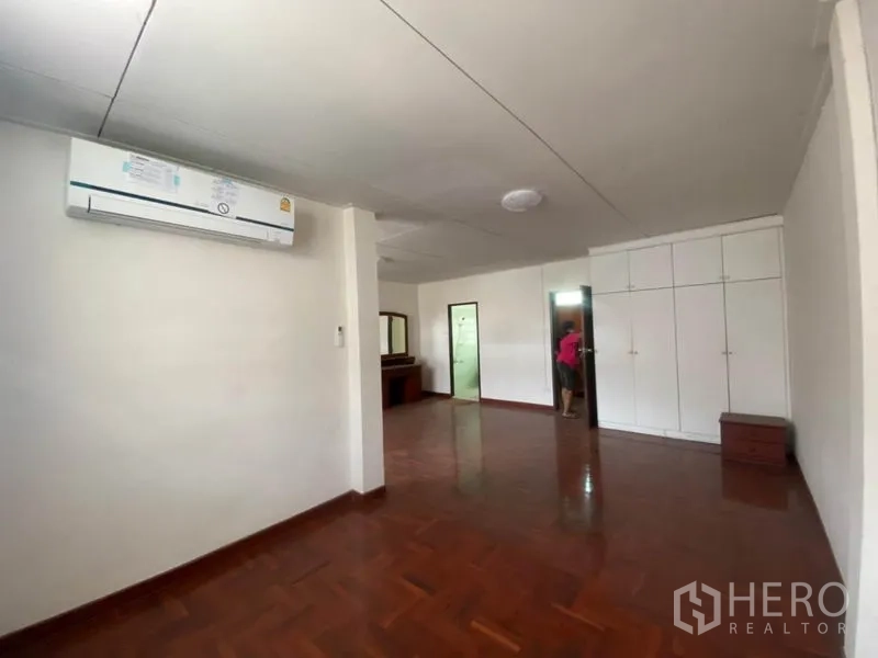 联排别墅 出租在Watthana, Bangkok - 主卧配空调、白色内置柜，并带卫浴入口。