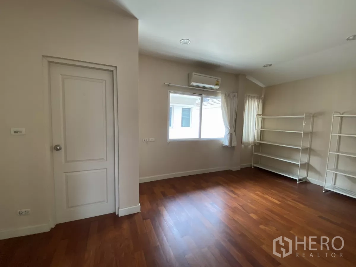 บ้าน ให้เช่าหรือขายในLak Si, Bangkok - ห้องนอนกว้าง พื้นไม้ หน้าต่าง และชั้นวางของโล่ง.