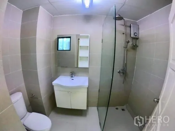 Office Space for rent in Khlong Toei, Bangkok - Tiled office bathroom with glass shower, water heater, vanity and toilet.