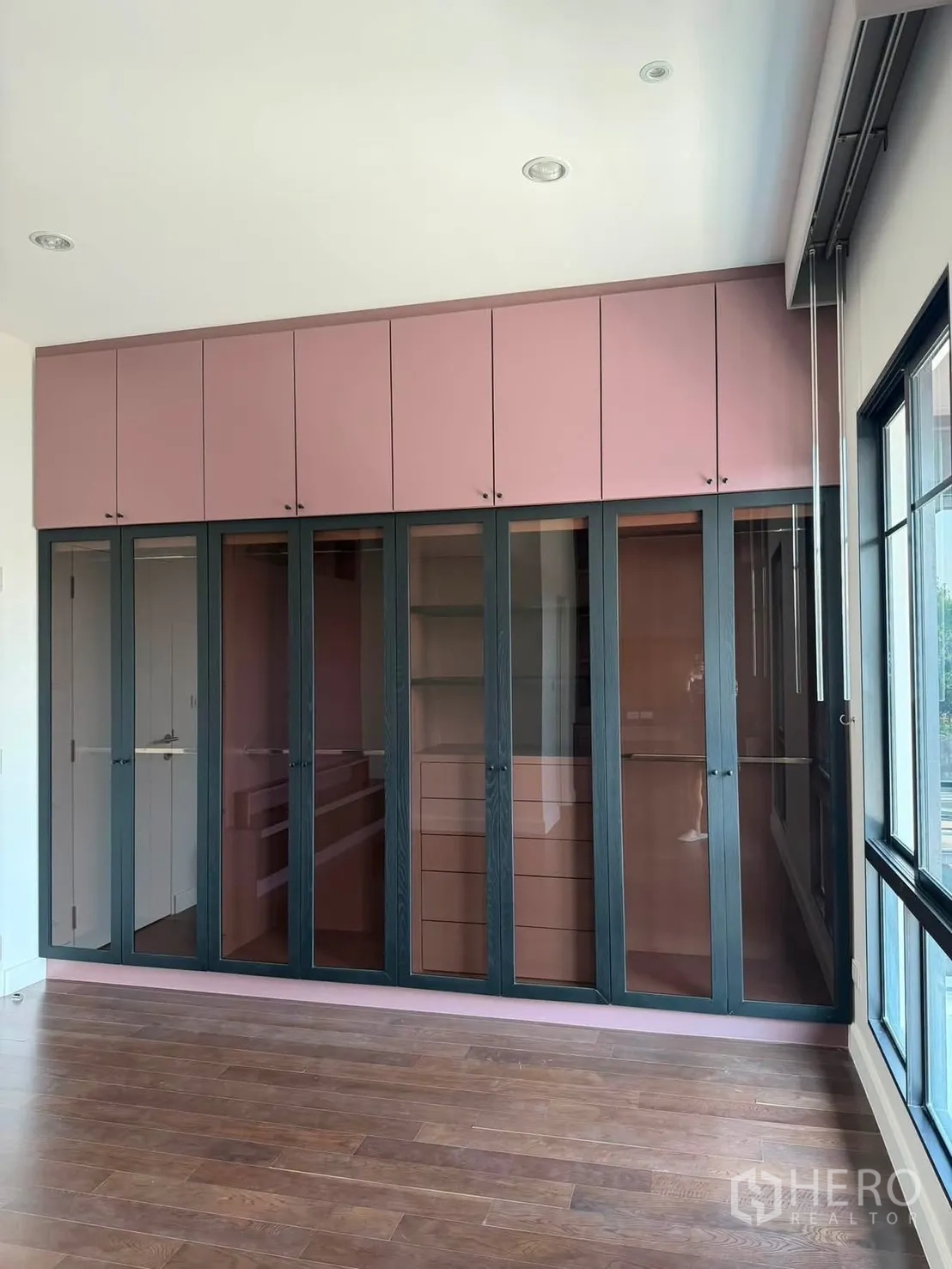 Detached House for rent or sale in Prawet, Bangkok - Large glass-front wardrobe with overhead cabinets in a bedroom.