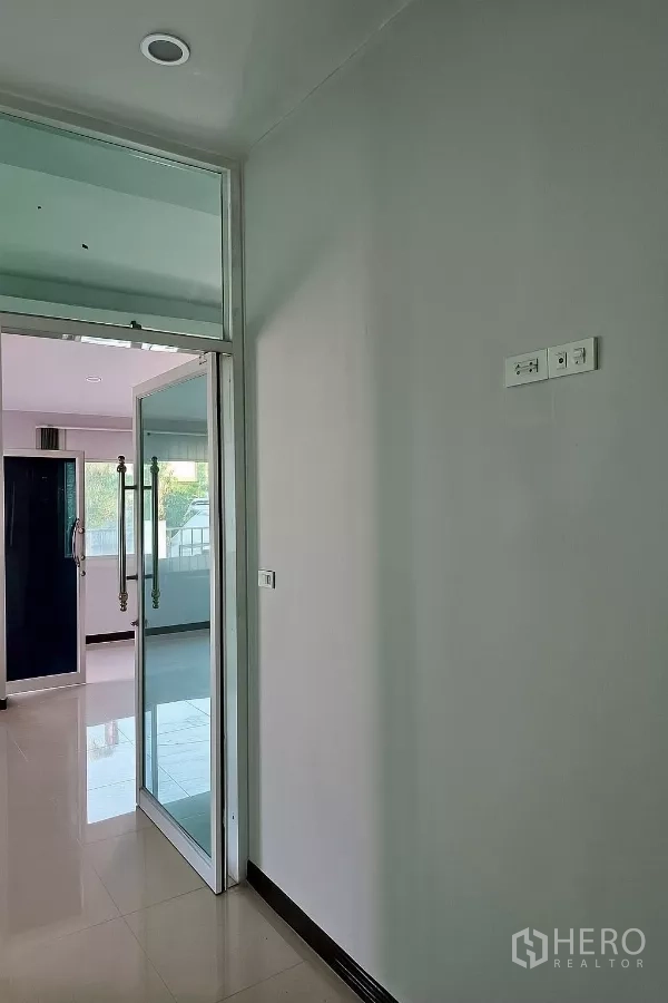 Home Office for rent in Bang Phli, Samut Prakan - Hallway with glass sliding doors and glossy tile floors linking office zones.
