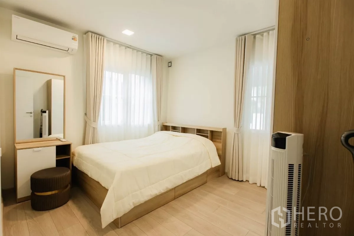 独立式住宅 出租或出售在Bang Phli, Samut Prakan - 次卧配双人床、梳妆台与轻纱窗帘。