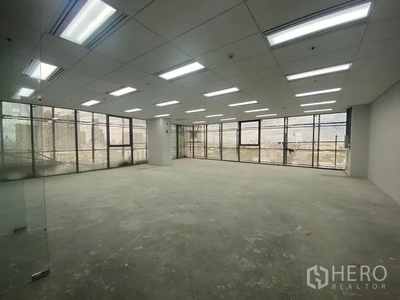 Office Space for rent - Unfurnished open-plan office floor with LED grid ceiling and wide windows offering city views.