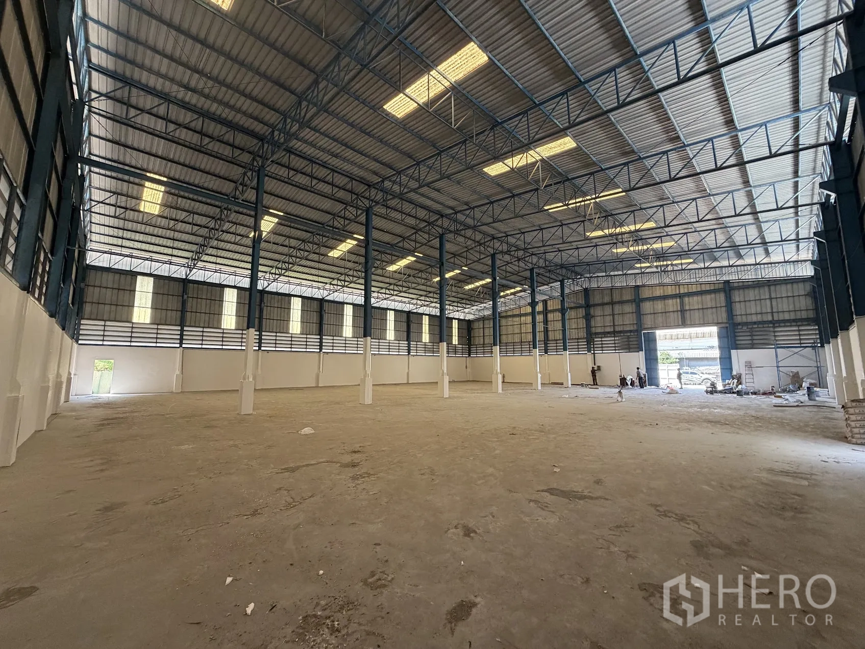 Factory for rent in Bang Sao Thong, Samut Prakan - Open-plan factory floor with high-clear roof and large roller shutter entrance at the far end.