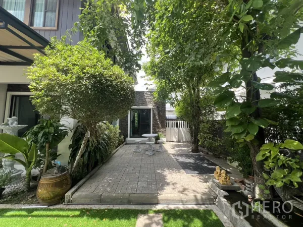 Detached House for rent in Bang Phli, Samut Prakan - Paved patio surrounded by mature greenery with a white outdoor table set.