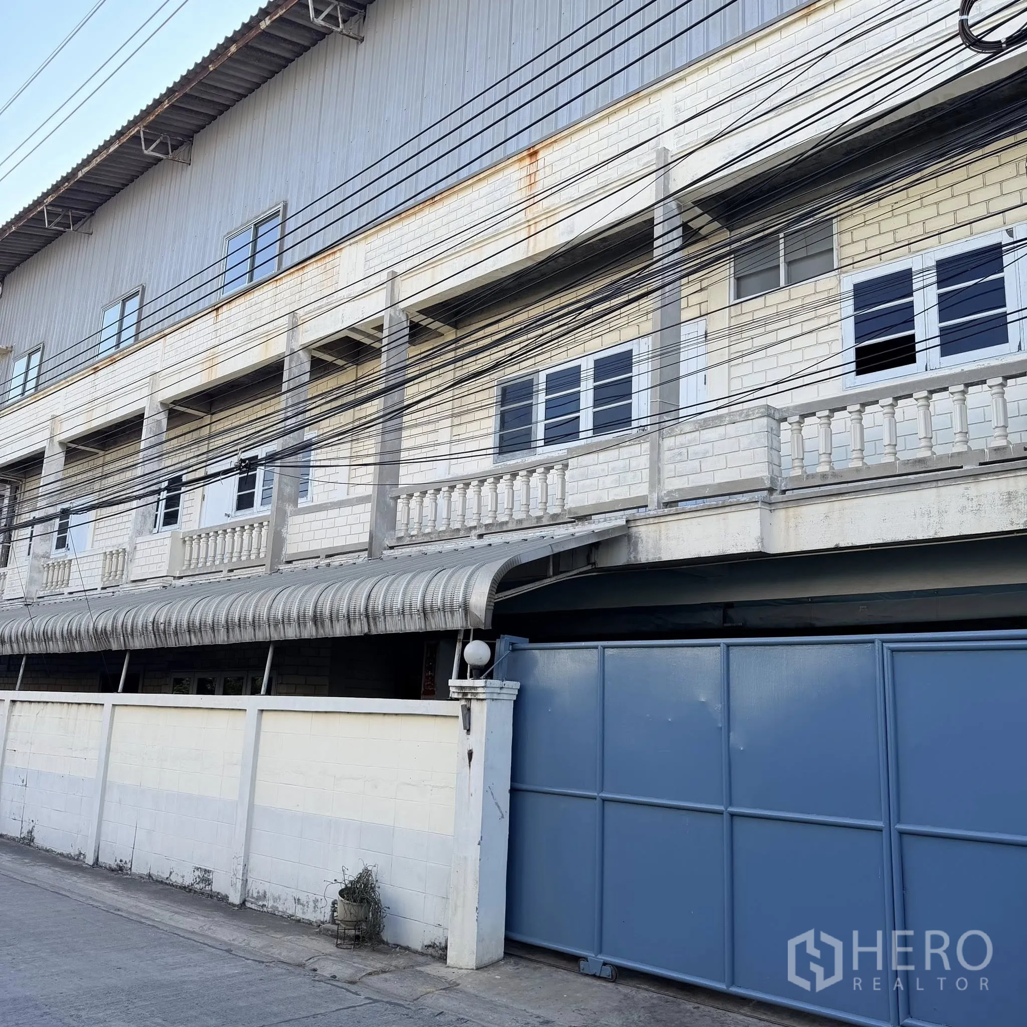 工厂 for rent in Phra Pradaeng, Samut Prakan - 工厂临街立面，围墙与多层办公楼及大门。