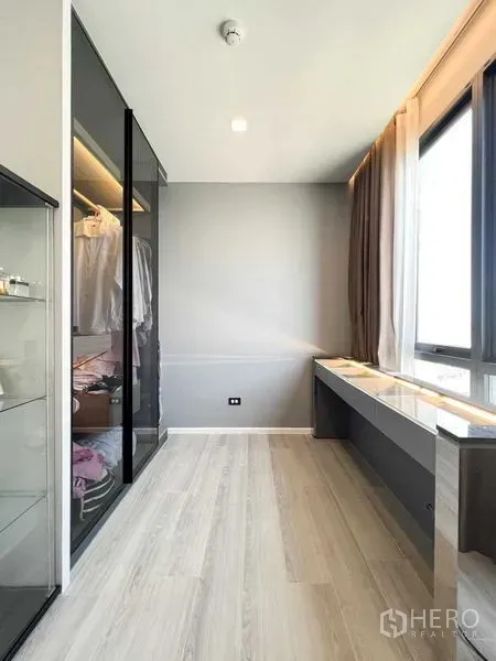 Condominium for rent or sale - Dressing area with floor-to-ceiling windows, built-in desk and glass-front closet.