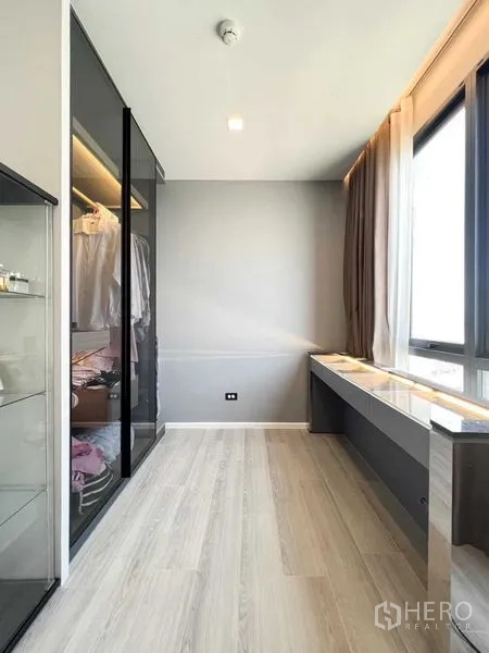 Condominium for rent or sale - Dressing area with floor-to-ceiling windows, built-in desk and glass-front closet.