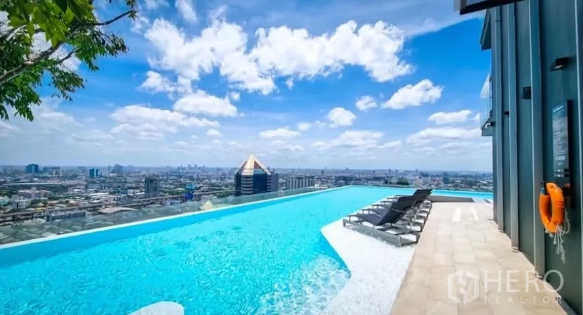 Condominium for rent in Chatuchak, Bangkok - Rooftop infinity pool with panoramic Bangkok skyline and sun loungers.