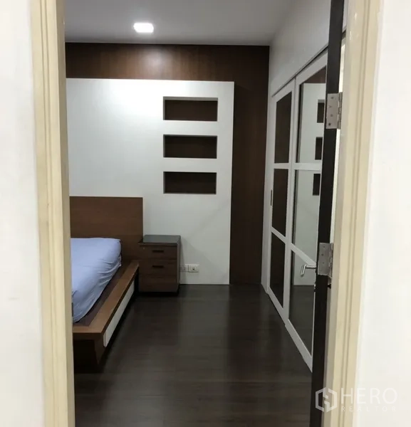 คอนโด ให้เช่าในKhlong Toei, Bangkok - ทางเข้าห้องนอนพร้อมชั้นบิวท์อิน โต๊ะข้างเตียง และตู้เสื้อผ้าบานเลื่อน