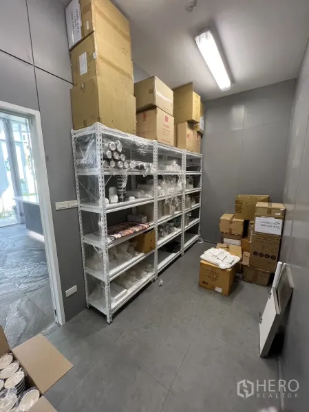 零售空间 出租在Khlong Toei, Bangkok - 后场储物间，配金属置物架与地砖地面。