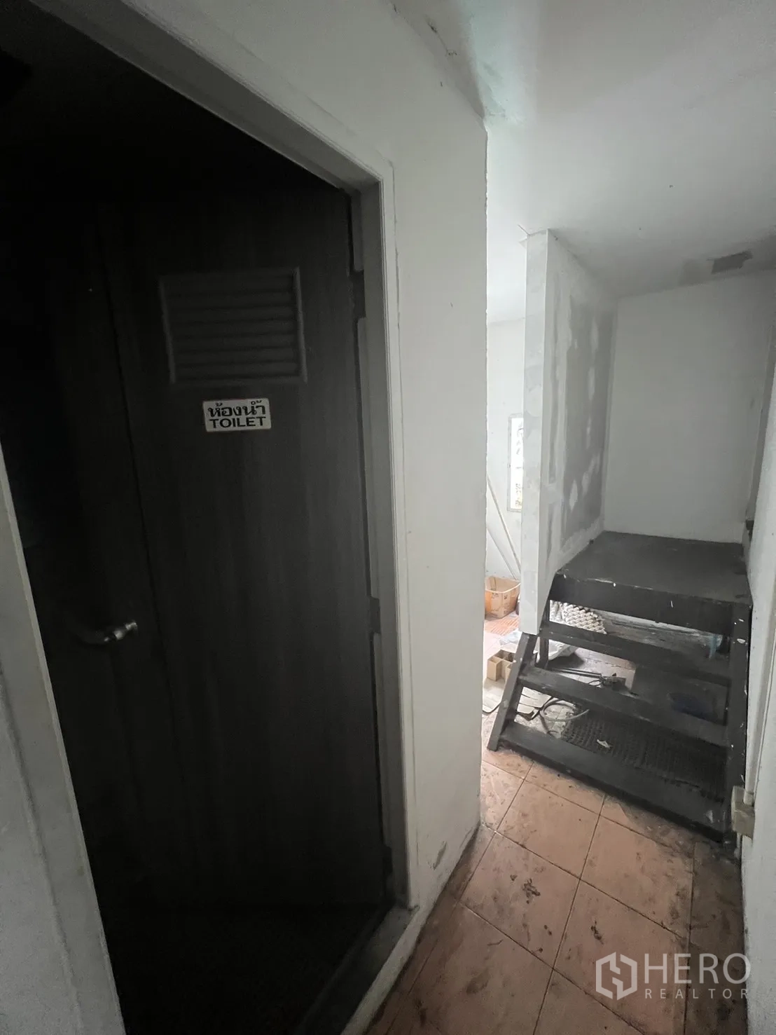 อาคารพาณิชย์ ให้เช่าในKhlong Toei, Bangkok - โถงชั้นบนมีประตูห้องน้ำและบันไดเหล็กบริการข้างพื้นกระเบื้อง