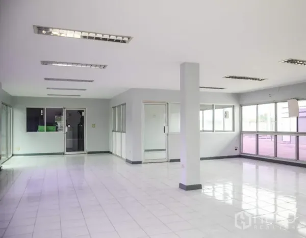 Factory for rent in Pathum Thani - Bright office interior with tiled floors, glass partitions, and fluorescent lighting.