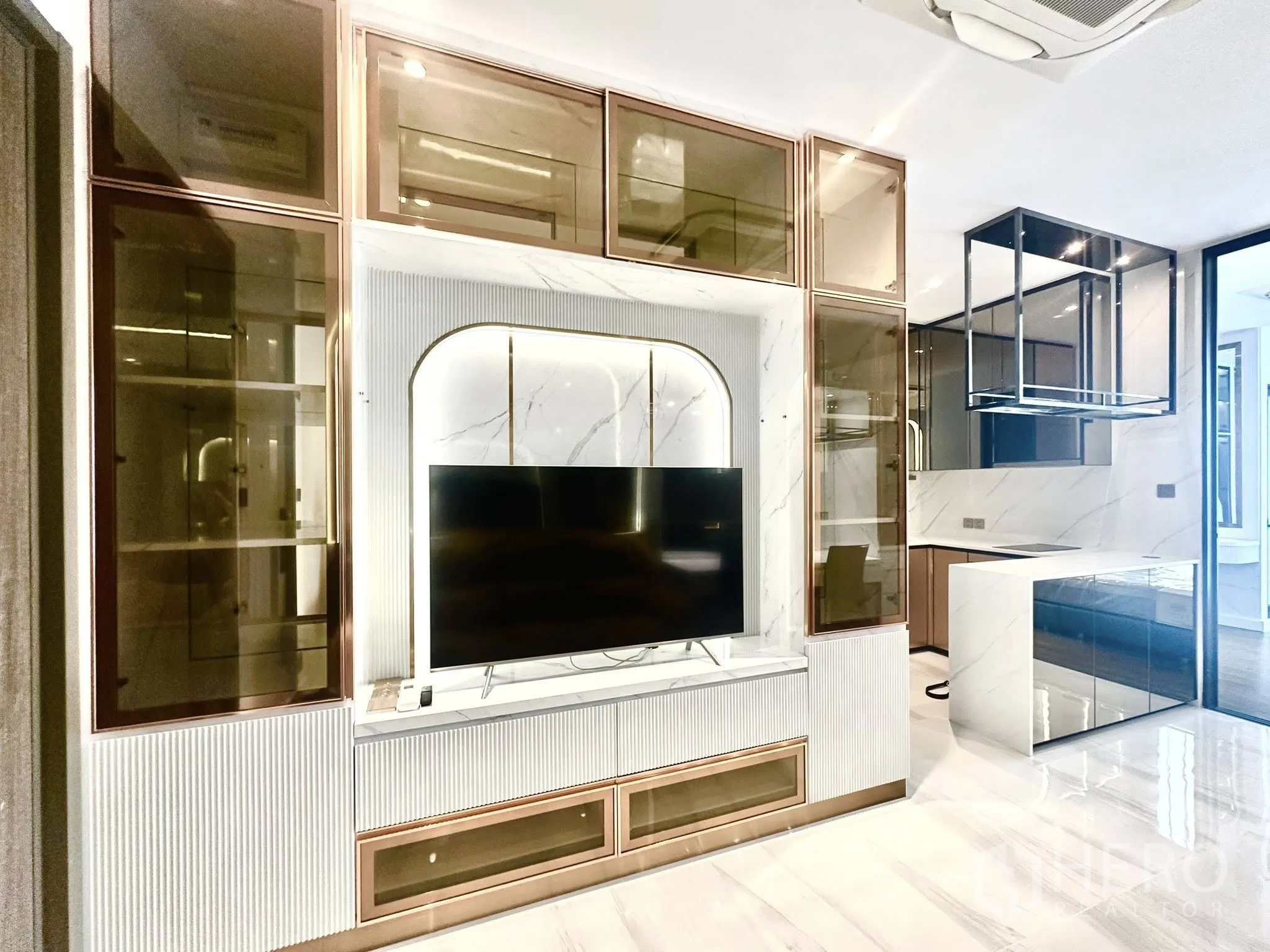 คอนโด for rent in Sathon, Bangkok - ผนังทีวีบิลท์อินกรุกระจกพร้อมตู้เก็บของติดกับไอแลนด์ครัวดีไซน์โมเดิร์น