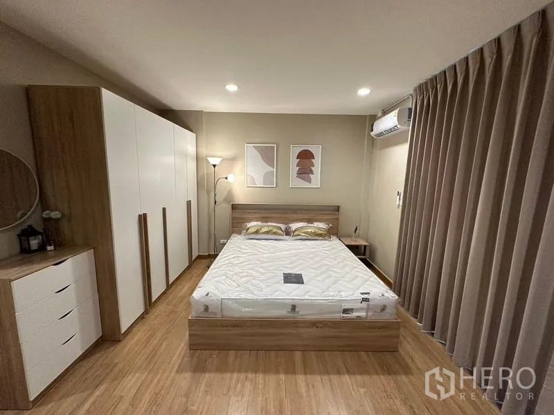 Townhouse for rent in Chom Thong, Bangkok - Master bedroom with double bed, large wardrobes, wood flooring, curtains and air conditioner.