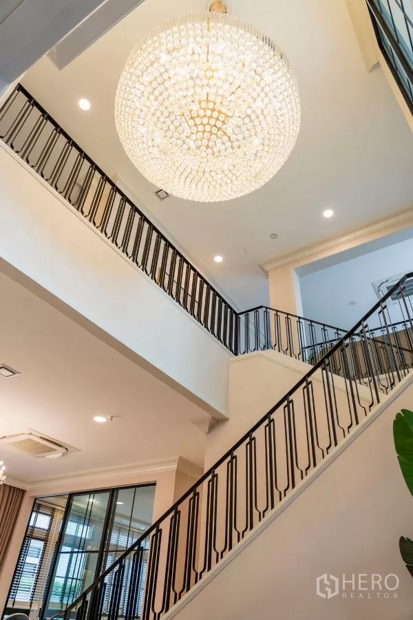 Detached House for rent in Saphan Sung, Bangkok - Double-volume foyer with statement round chandelier and black railings.