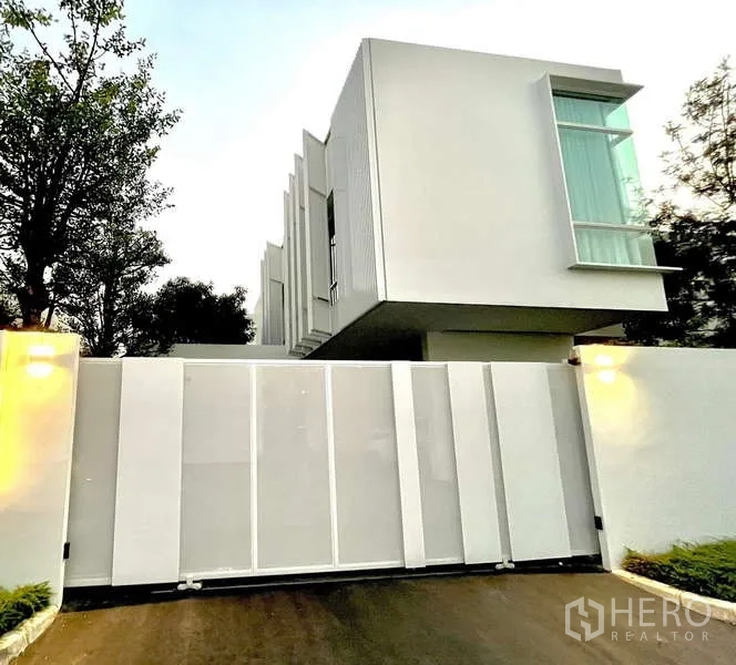 独立式住宅 出租或出售在Bang Phli, Samut Prakan - 现代白色独栋外立面，高墙与滑动大门。