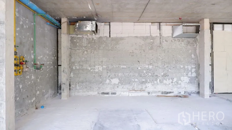 零售空间 出租在Watthana, Bangkok - 毛坯商用单元的设备墙，展示管线与通风口。