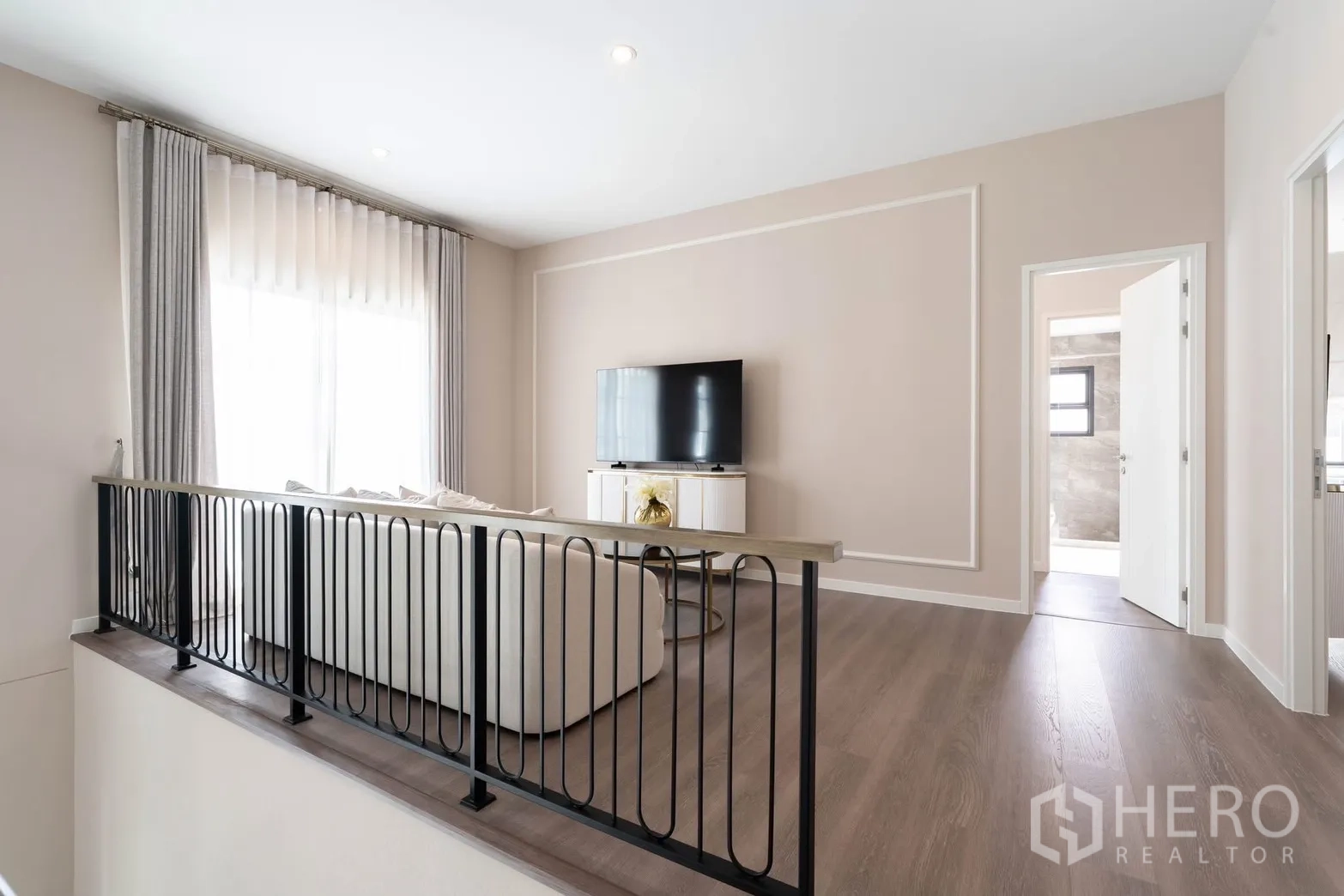 Detached House for rent in Bang Phli, Samut Prakan - Bright upstairs lounge with black metal railing, TV console, and wood flooring.