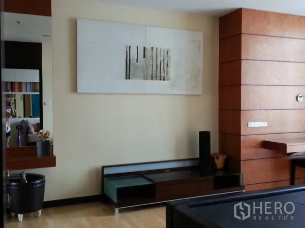 คอนโด ให้เช่าในKhlong San, Bangkok - โซนพักผ่อนกว้าง ผนังตกแต่งลายไม้ ชั้นวางทีวี งานศิลป์ และพื้นลามิเนตสีอ่อน