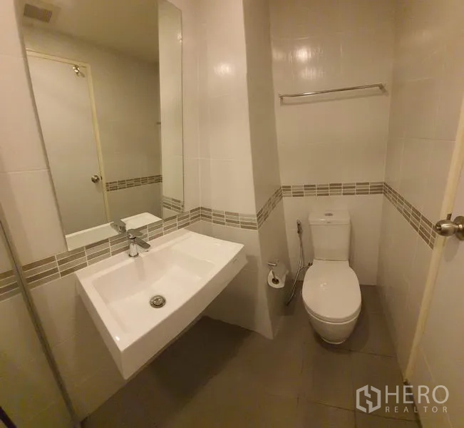 คอนโด ขายในChatuchak, Bangkok - ห้องน้ำสะอาดพร้อมอ่างล้างหน้าเหลี่ยม โถสุขภัณฑ์ และผนังพื้นกระเบื้องโทนกลาง