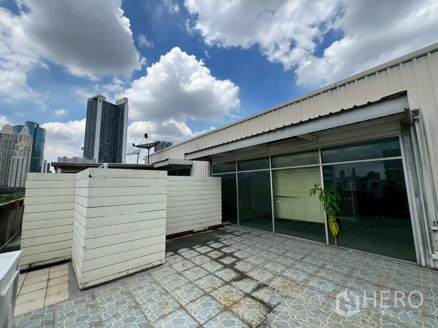 Shophouse for rent - Rooftop terrace with city skyline views under cloudy sky.