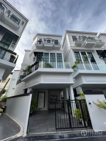 สำนักงานที่บ้าน ให้เช่าหรือขายในWatthana, Bangkok - ด้านหน้าโฮมออฟฟิศสีขาว 3 ชั้น พร้อมที่จอดรถมีประตูรั้วและกระจกบานใหญ่