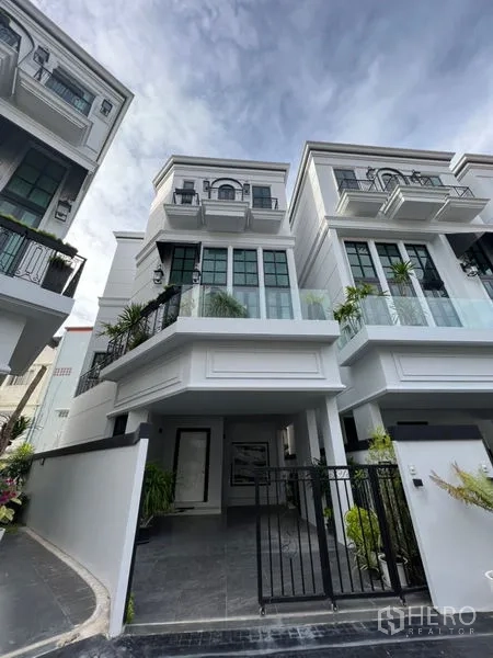 สำนักงานที่บ้าน ให้เช่าหรือขายในWatthana, Bangkok - ด้านหน้าโฮมออฟฟิศสีขาว 3 ชั้น พร้อมที่จอดรถมีประตูรั้วและกระจกบานใหญ่