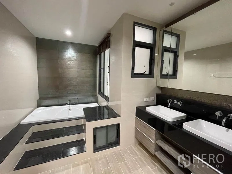 Detached House for rent in Bang Na, Bangkok - Master bathroom with built-in bathtub and double vanity countertop.