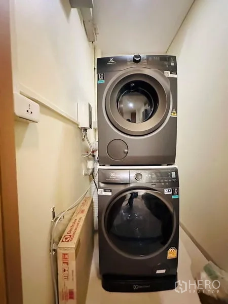 公寓 出租在Bang Rak, Bangkok - 紧凑洗衣区，叠放式滚筒洗衣机与烘干机。