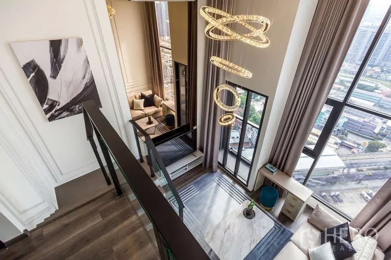 Condominium for rent or sale - View from mezzanine to living room with pendant ring lights and tall windows.