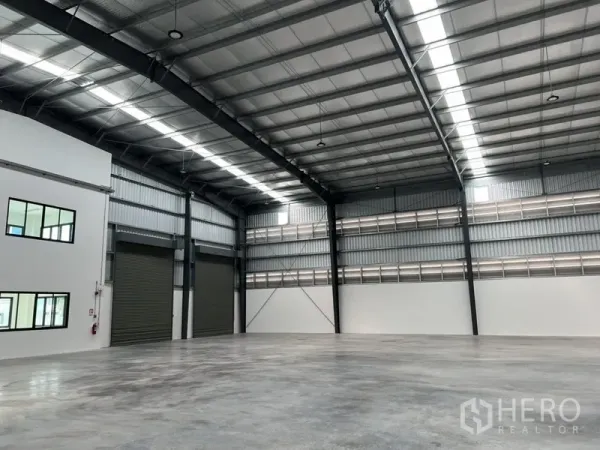 Factory for rent in Bang Sao Thong, Samut Prakan - Open factory floor with twin roller shutters and insulated arched roof.