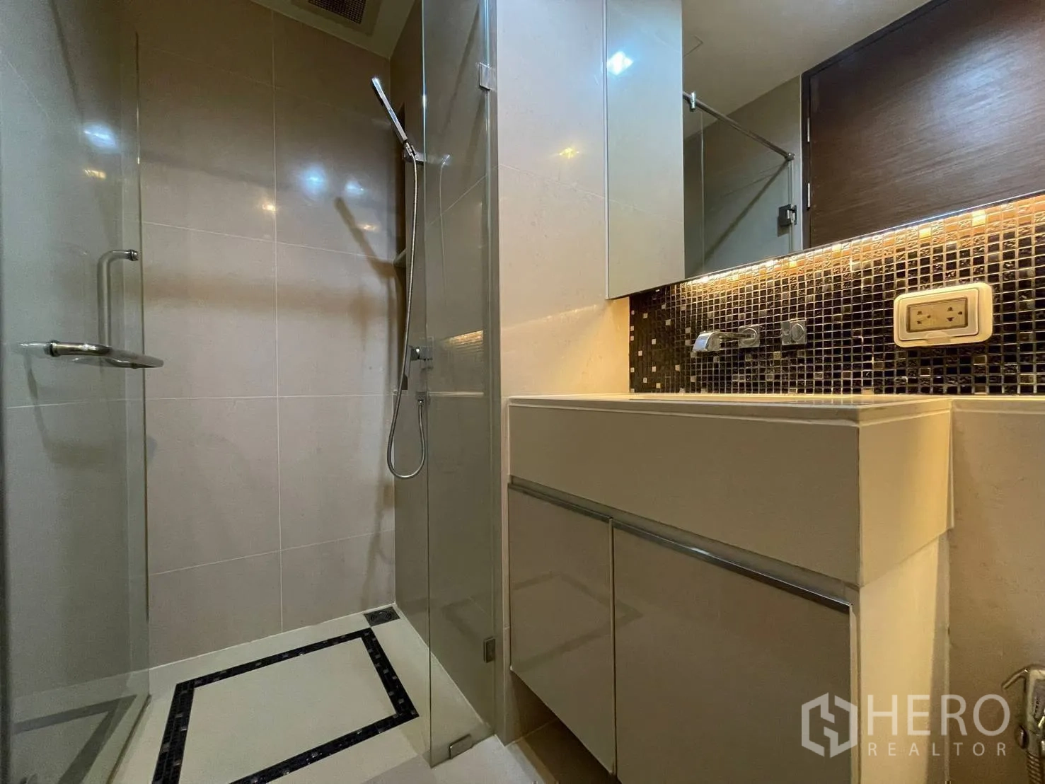 Condominium for rent or sale in Bang Rak, Bangkok - Glass-enclosed shower with handheld spray and illuminated vanity.