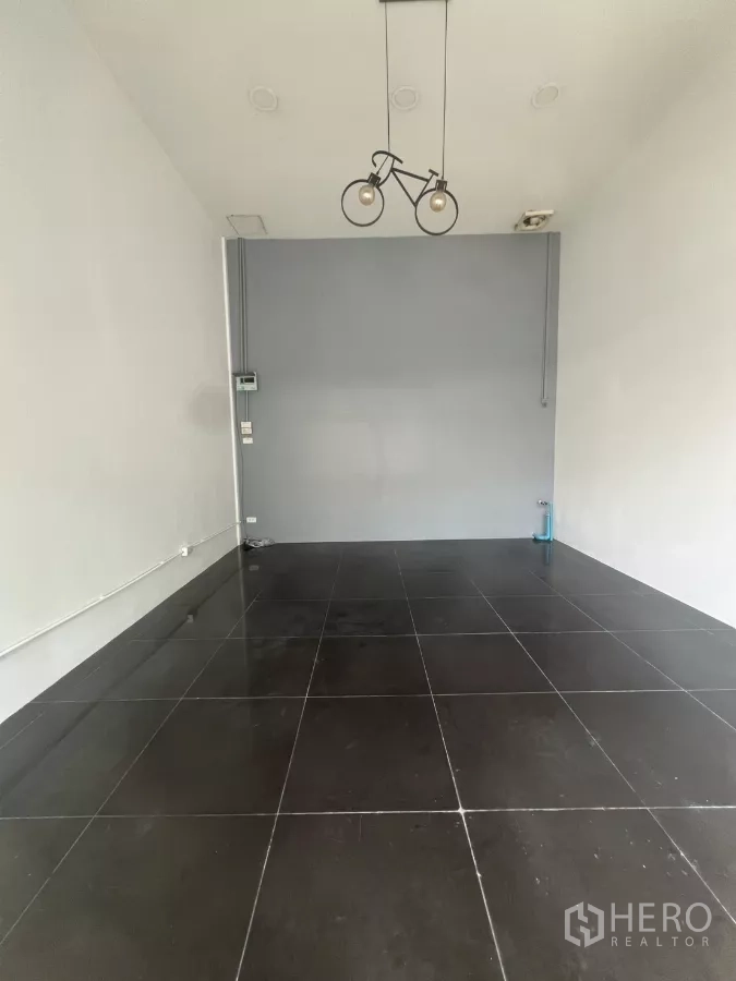 Retail Space for rent in Khlong Toei, Bangkok - Narrow retail unit with large floor tiles, recessed lighting, and utility points ready for fit-out.