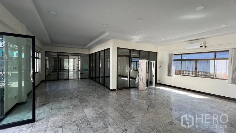 Warehouse for rent in Thanyaburi, Pathum Thani - Office corridor with glass-partitioned meeting rooms and sliding glass doors.