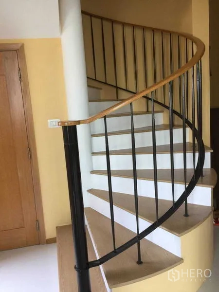 คอนโด ให้เช่า - ภาพระยะใกล้บันไดเวียน ราวไม้และราวเหล็กสีดำ