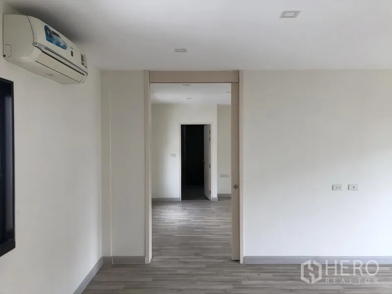 Townhouse for rent or sale in Saphan Sung, Bangkok - Connecting upstairs rooms with wood floors and a sliding partition, fitted with air conditioning.