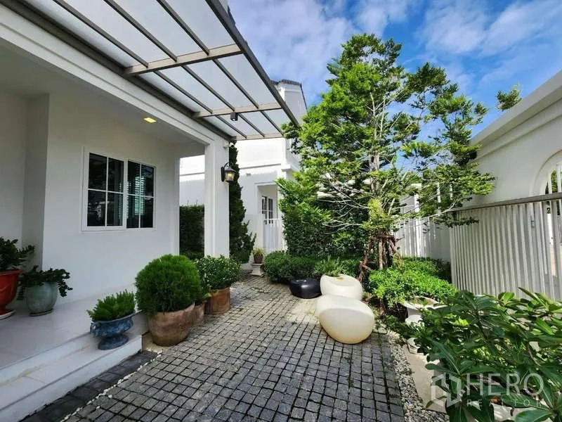 Detached House for rent or sale in Bang Phli, Samut Prakan - Landscaped courtyard with pavers, shade canopy and mature tree.