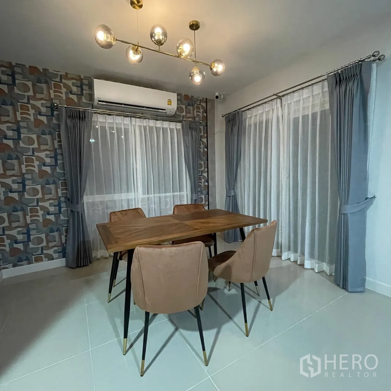 Semi-detached House for rent in Bang Phli, Samut Prakan - Contemporary dining area with wood table, four upholstered chairs, pendant lighting and sheer curtains.