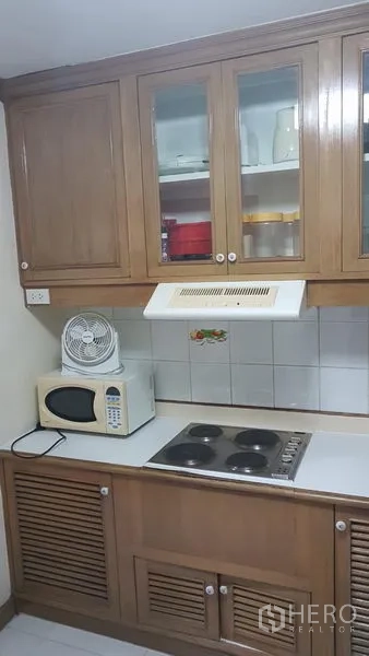 คอนโด ให้เช่าในWatthana, Bangkok - ครัวขนาดกะทัดรัด ตู้ไม้บานกระจก เตาไฟฟ้า ไมโครเวฟ และเครื่องดูดควัน