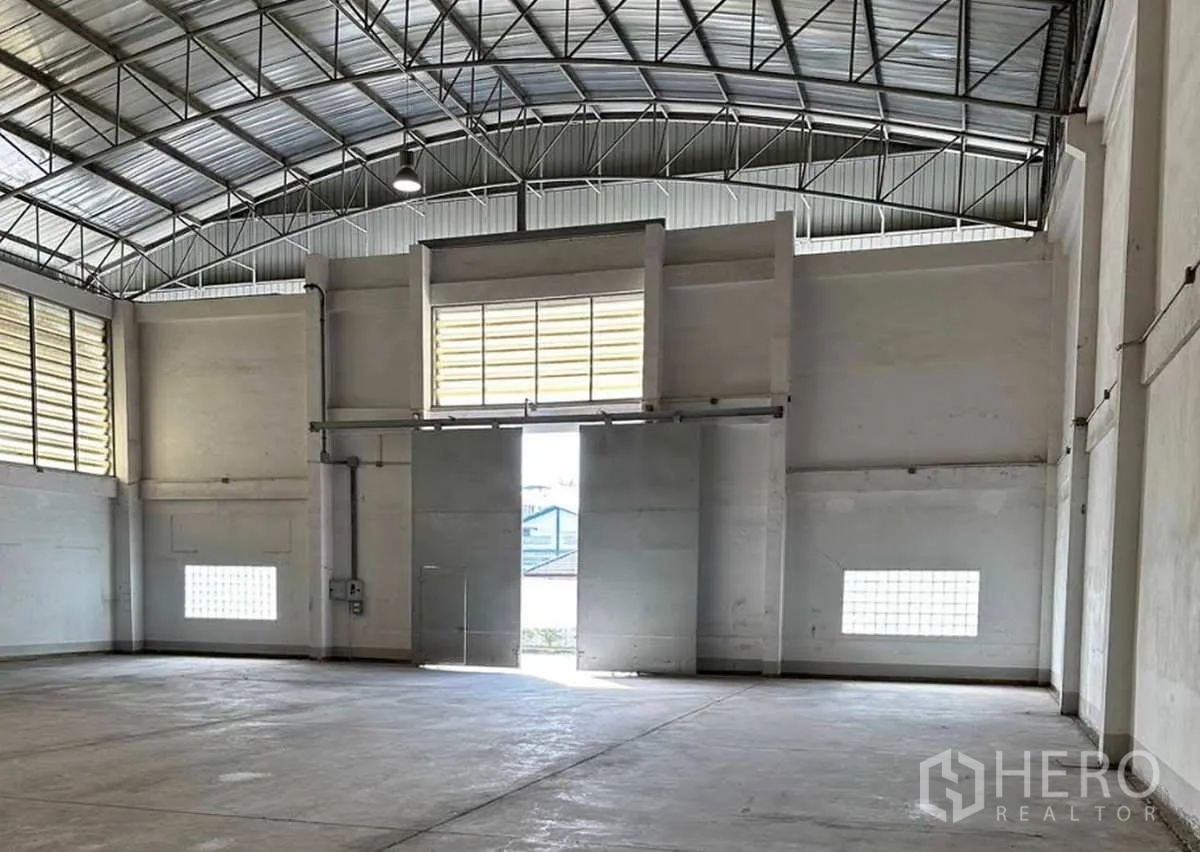 工厂 出租在Krathum Baen, Samut Sakhon - 厂房内部空间开阔，钢结构高屋顶，大型滑动装卸门与通风百叶。
