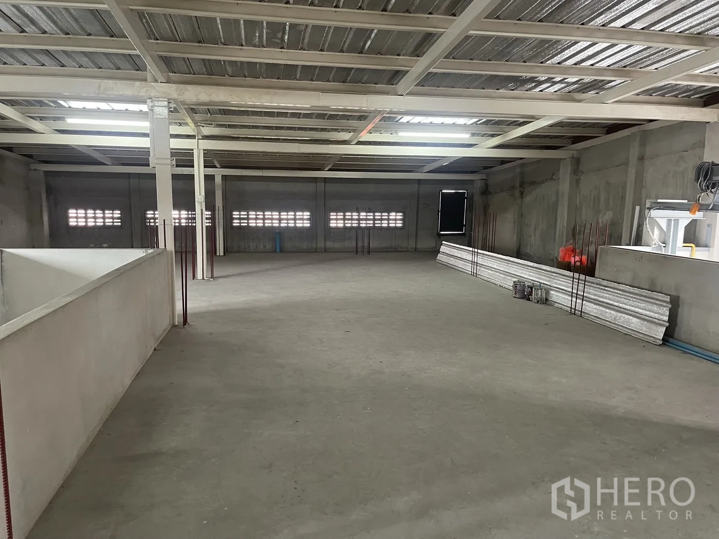 Home Office for rent in Suan Luang, Bangkok - Rooftop warehouse-style space with steel roof structure and open concrete floor.