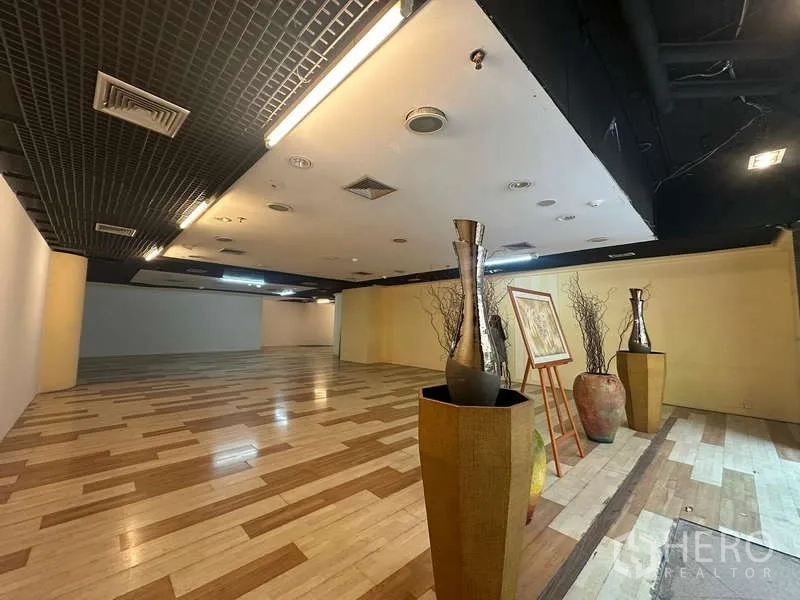 零售空间 出租 - 展示区摆放花瓶与装饰画，旁有米黄色特色墙。