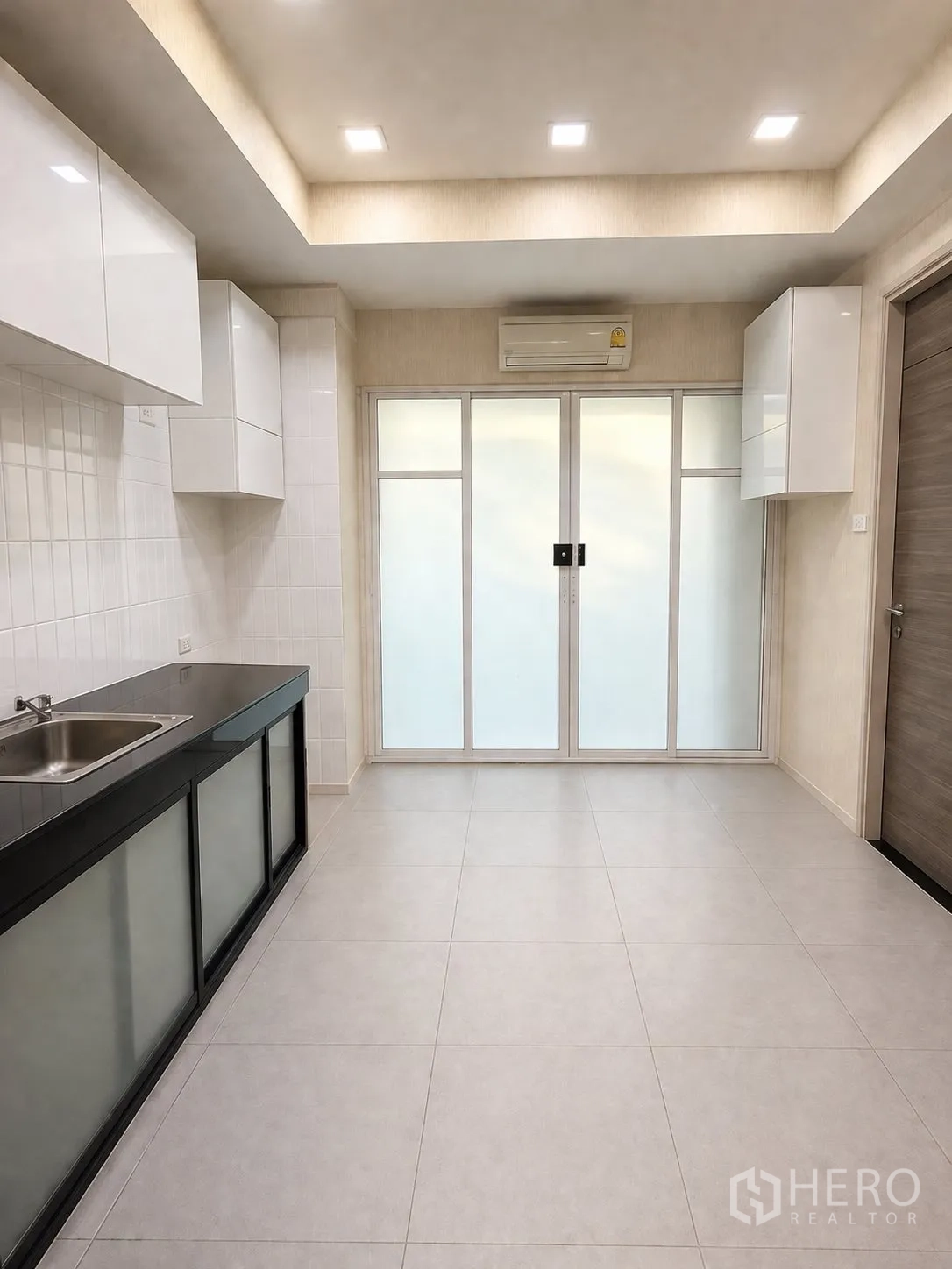 Home Office for rent or sale in Yan Nawa, Bangkok - Secondary pantry room with white cabinets, sliding glass doors, and tiled floor.