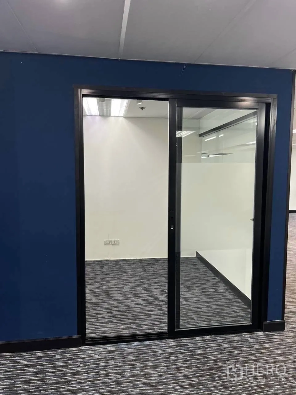 Office Space for rent in Khlong Toei, Bangkok - Blue feature wall with a sliding glass door to a private office.