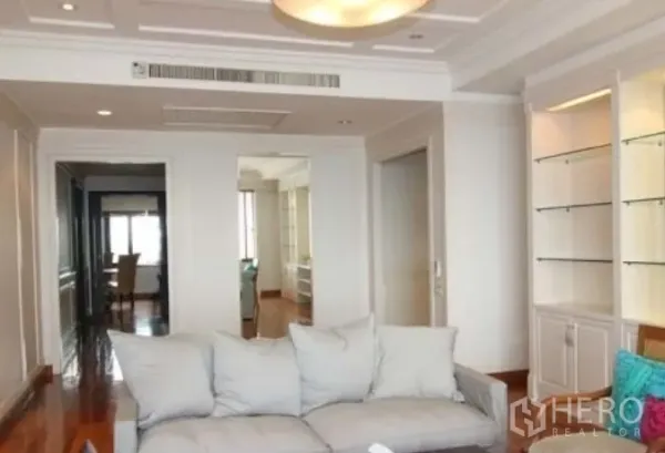 公寓 出租在Sathon, Bangkok - 客厅明亮，吊顶与内置展示柜相配，沙发面向走廊，位于沙吞公寓内。